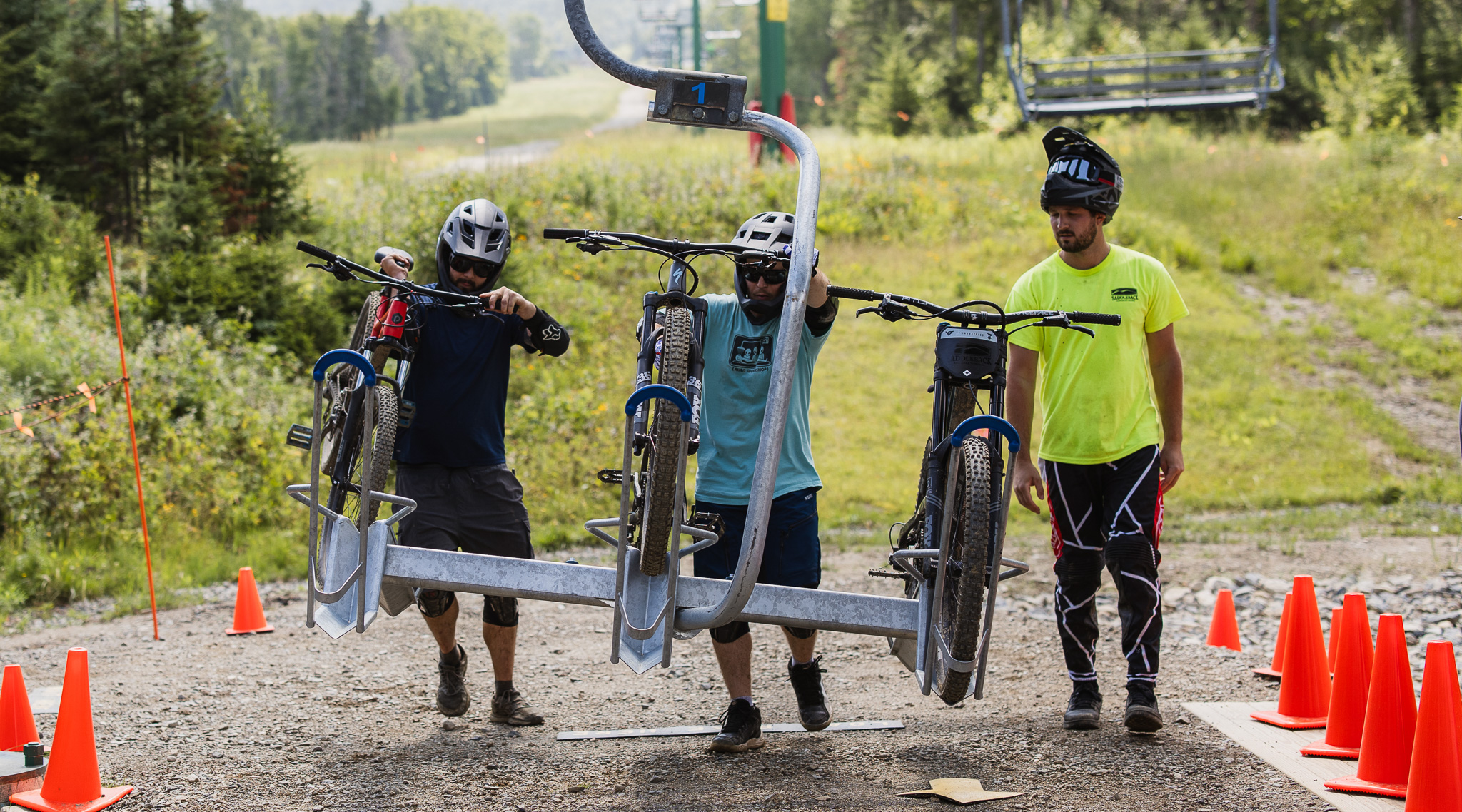 Three mountain bike riders loading bikes on the lift